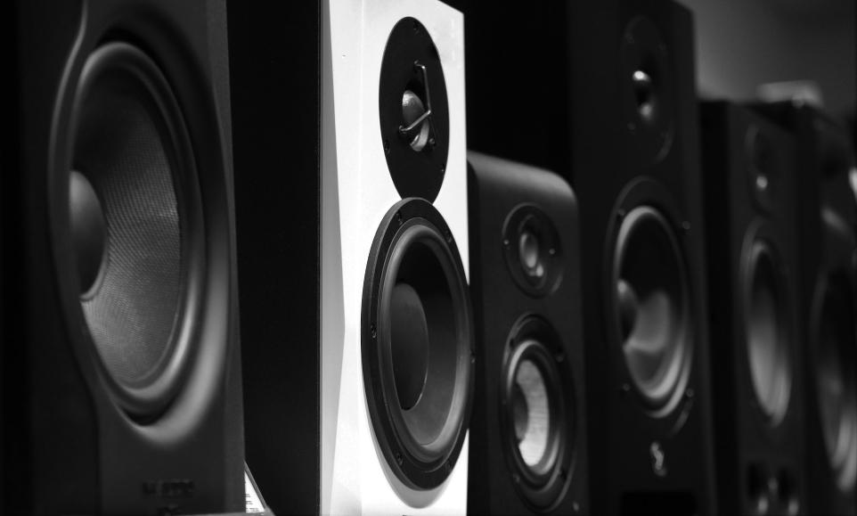 black and gray speakers on brown wooden table